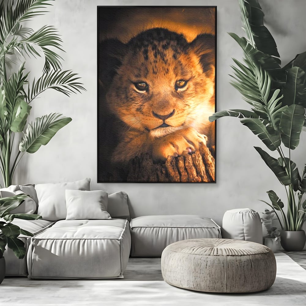 Tablou canvas cu tablou canvas cu portret de pui de leu, in rama de aluminiu negru, pe perete intr-un living